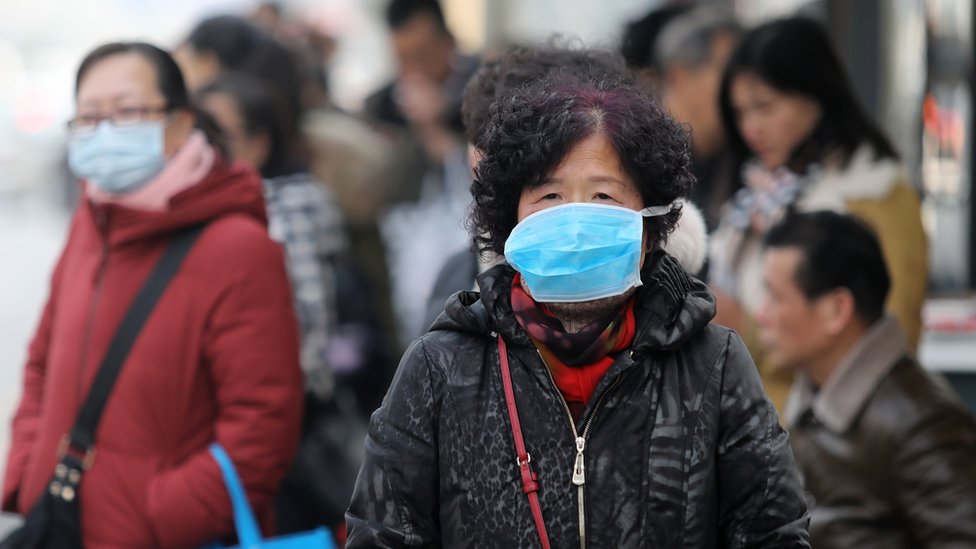 Virus i Kina: „Misteriozni“ korona virus - šta znamo do sada 1 Chinese residents wear masks at a bus station near the closed Huanan Seafood Wholesale Market