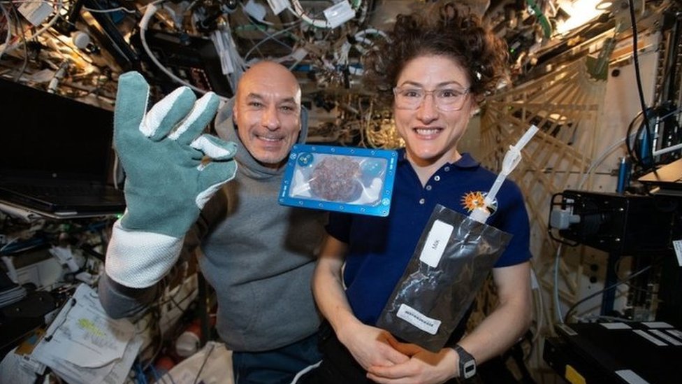 NASA of ISS commander Luca Parmitano and astronaut Christina Koch with milk and cookies on board the International Space Station