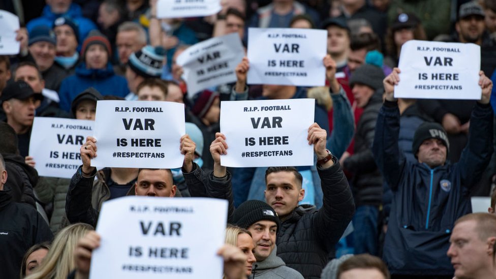 Priče o fudbalu na radnom mestu „izostavljaju žene - ograničite ih" 2 Fans hold up signs saying "VAR is here"