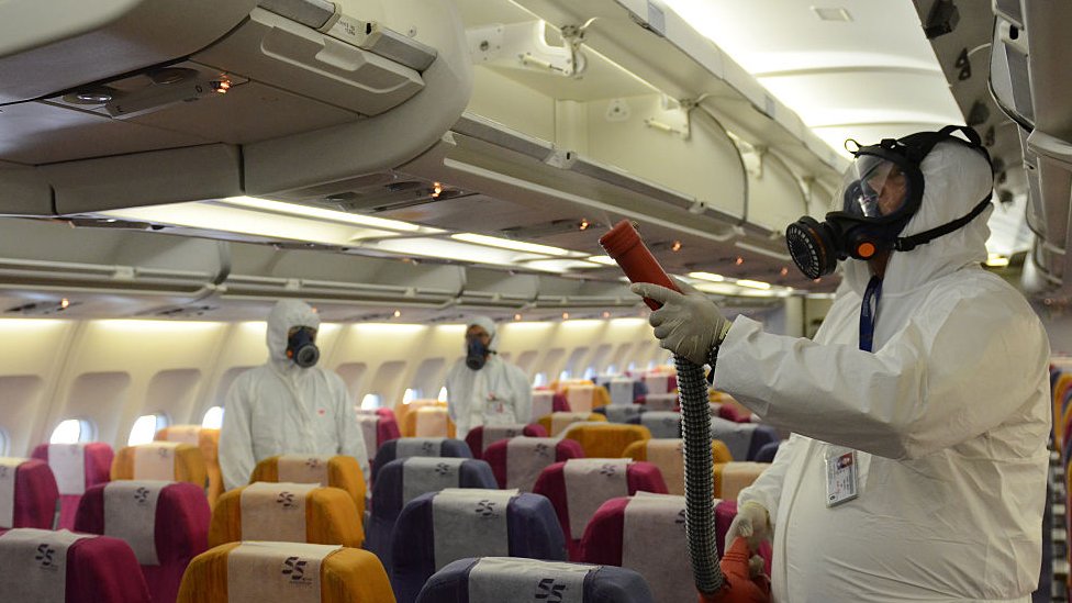 Medicinski radnici prskaju antiseptik unutar aviona na Tajlandu 2015. godine