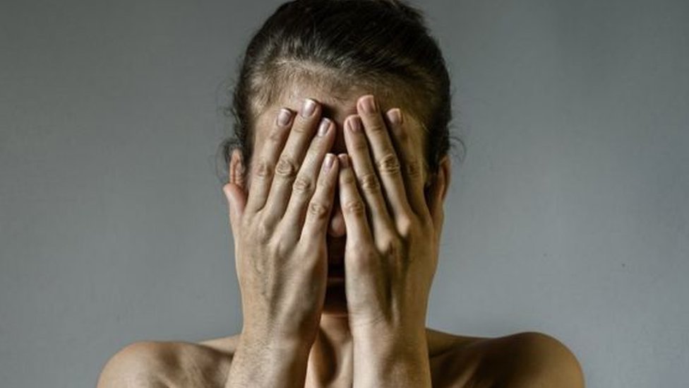 Žena pokriva lice rukama