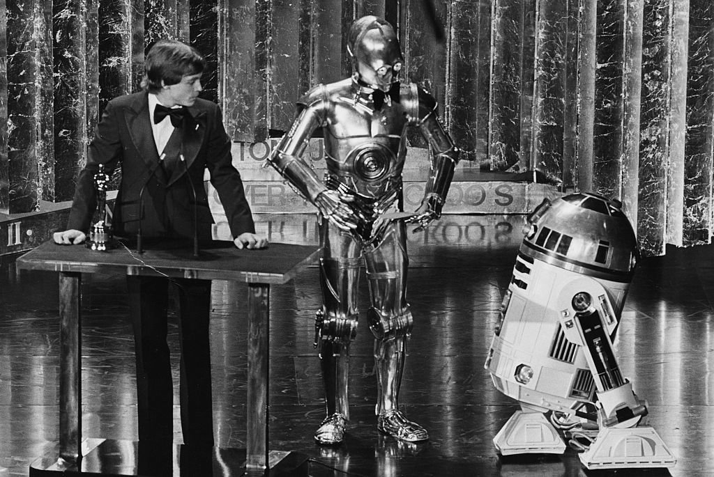Actor Mark Hamill presenting an award with his Star Wars co-stars C3PO and R2D2 at the 1978 Oscars