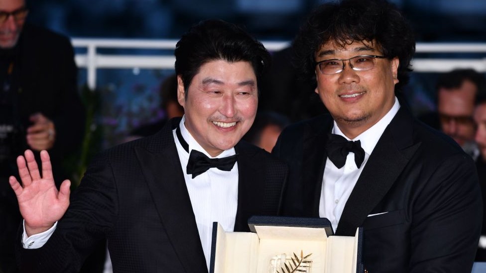 Parasite's director Bong Joon-ho (right) poses with his Palme d'Or with actor Song Kang-ho