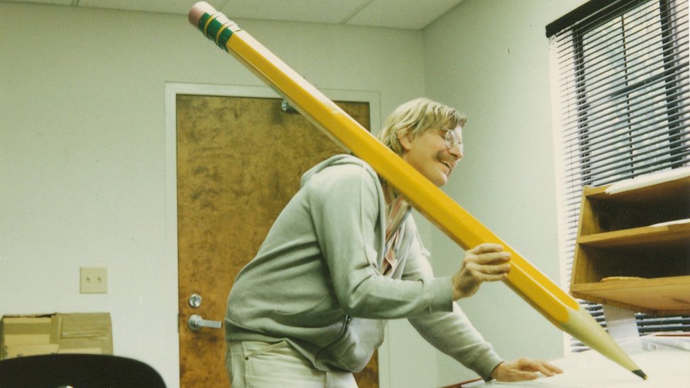 Mark drži ogromnu olovku tokom kratkog filma "Povratak u Nedođiju"