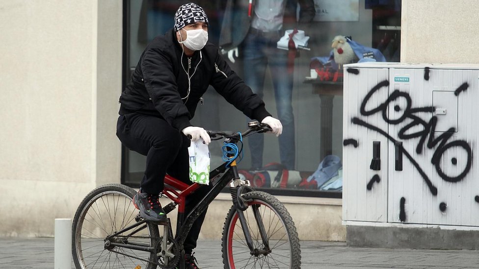muškarac na biciklu sa maskom
