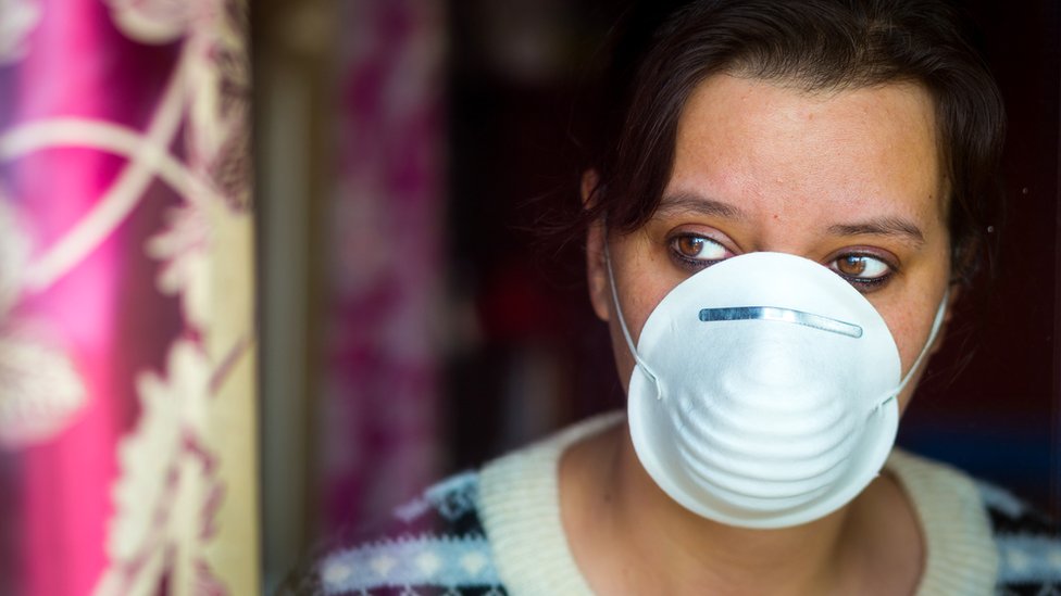 Korona virus: Četiri nova smrtna slučaja u Srbiji, Britanija i Njujork produžili karantin 1 Woman wearing a face mask looks out of a window