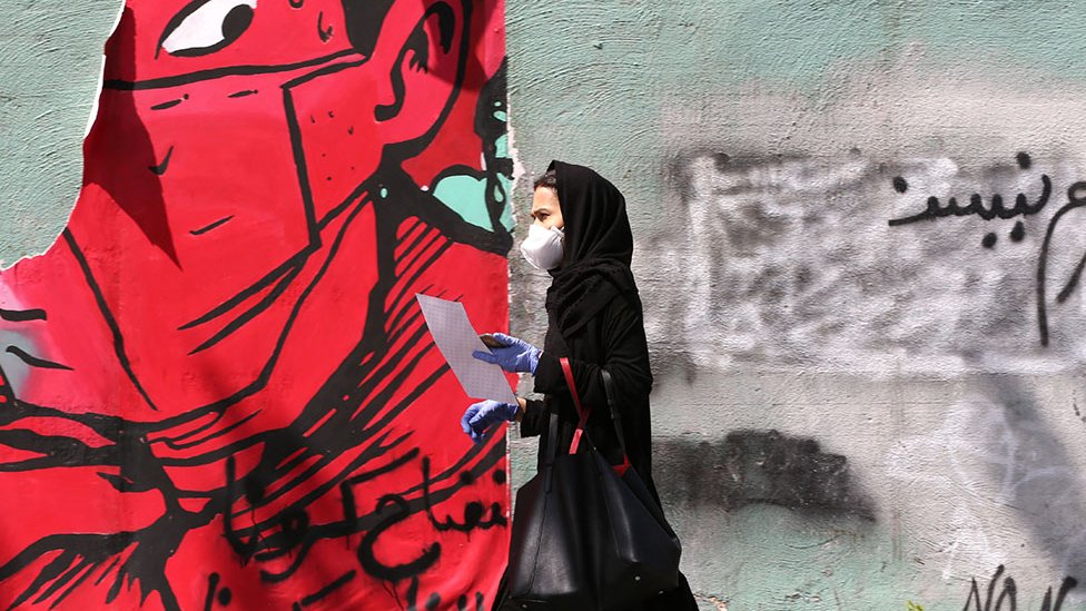 Korona virus: Zašto je teško praviti poređenja među zemljama sa epidemijom Kovida-19 2 Woman walks past graffiti in Tehran
