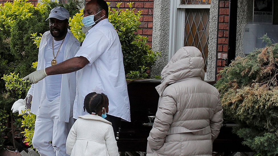 A pallbearer exits a funeral in Brooklyn