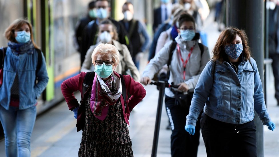 Korona virus: Prvi dan bez policijskog časa u Srbiji, Britanija razmatra popuštanje mera 1 Passengers in masks arrive at a railway station in Milan (3 May)