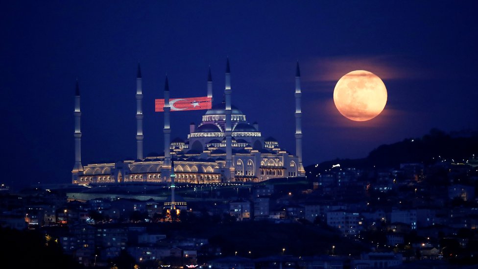 The full moon, also known as the Supermoon or Flower Moon, rises above the Camlica Mosque during the spread of the coronavirus disease (COVID-19), in Istanbul, Turkey