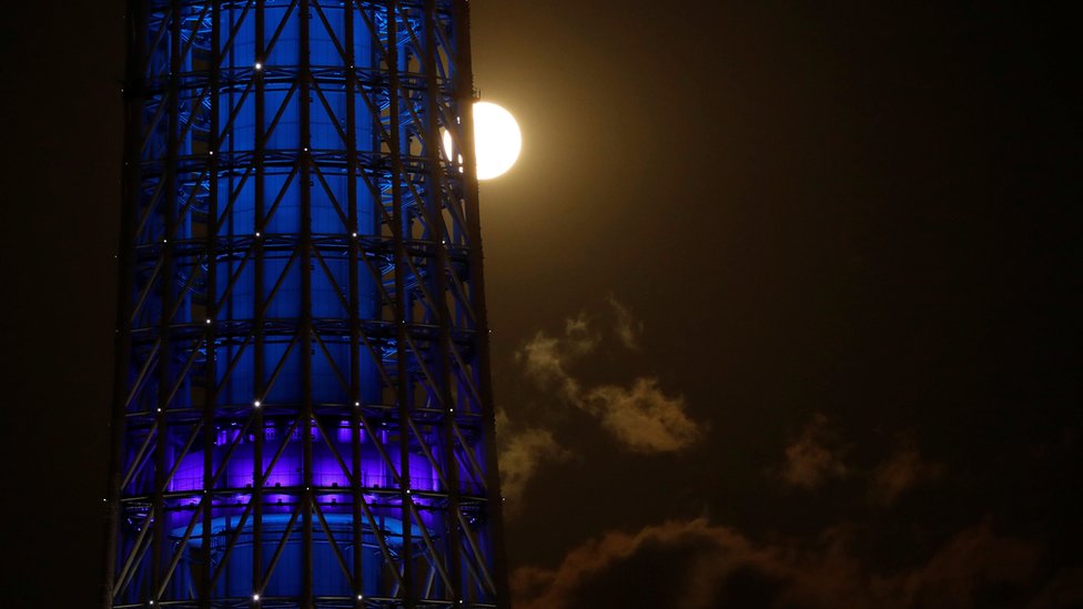 The full moon, also known as the Supermoon or Flower Moon, rises next to Tokyo Skytree in Japan
