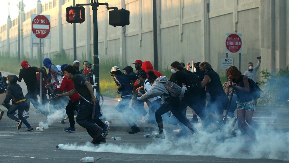 Smrt Džordža Flojda: Sukobi policije i demonstranata širom Amerike, situacija najgora u Minesoti 2 People run as tear gas canisters land near them during a protest sparked by the death of George Floyd while he was in police custody, in Minneapolis, Minnesota, 29 May 2020