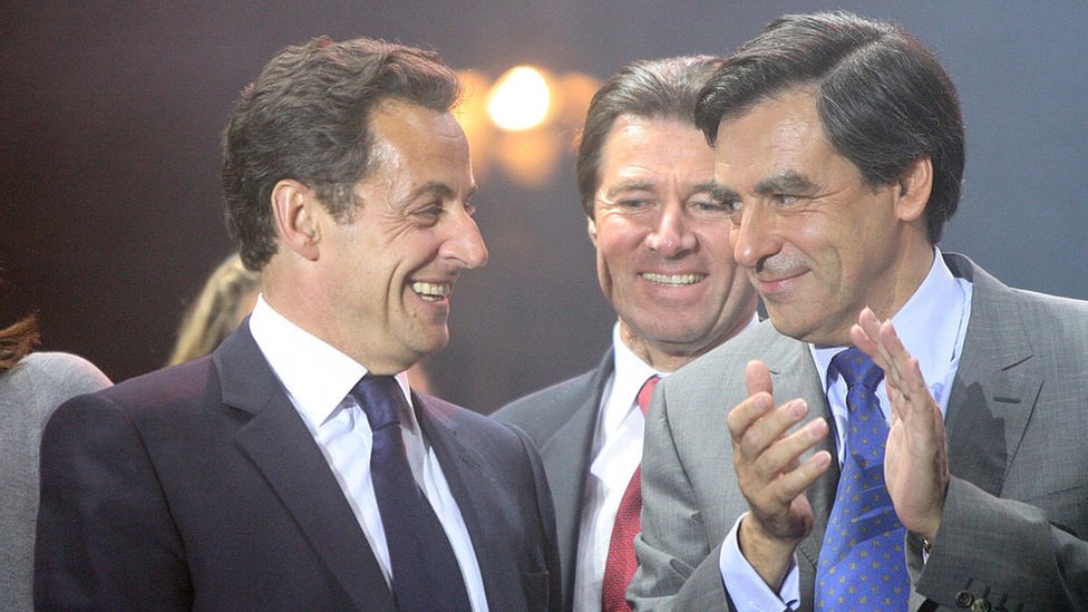 Nicolas Sarkozy, left, laughs on stage alongside Francois Fillon