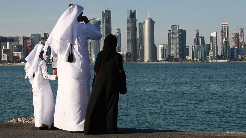 Klimatske promene: Naučnici su upozoravali na smrtonosne temperature za 50 godina – ali da li su one već stigle 2 A man and two children in traditional dress stare across water at a city in the Persian Gulf