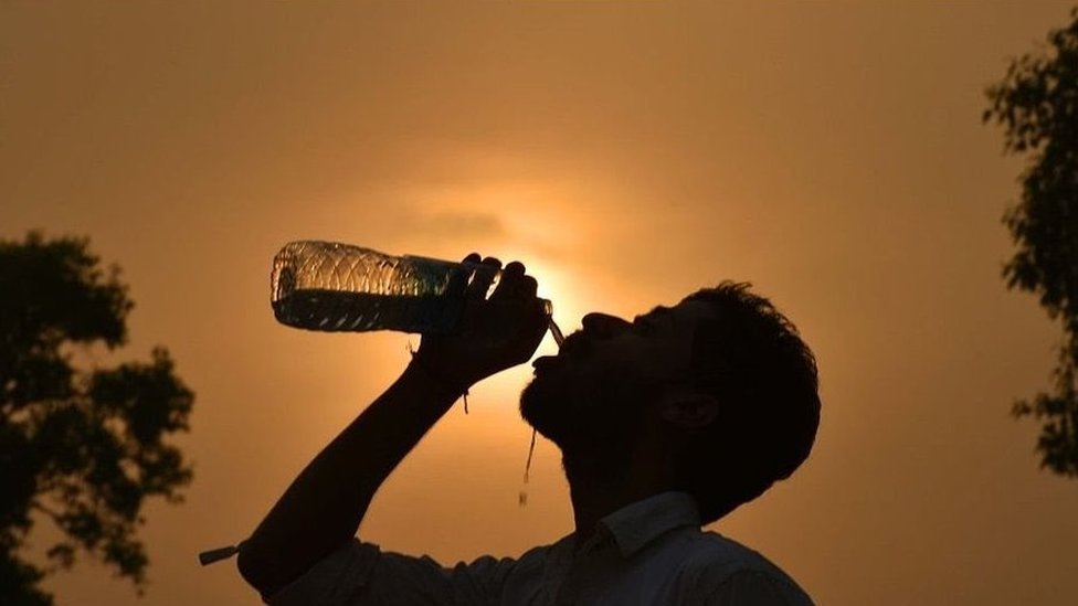 Klimatske promene: Naučnici su upozoravali na smrtonosne temperature za 50 godina – ali da li su one već stigle 1 A man drinks water from a bottle in front of a hot Sun