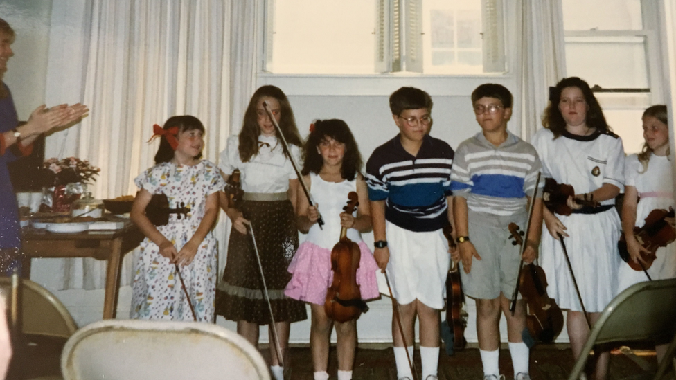 Jessica Hindman with her violin as a child - she is the third from the left