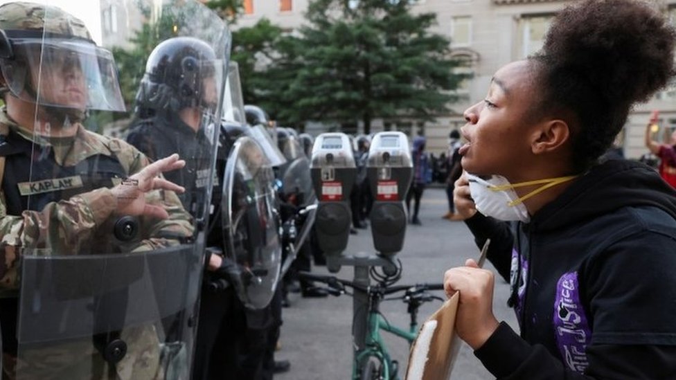 A demonstrator faces law enforcement officers during a rally near the White House