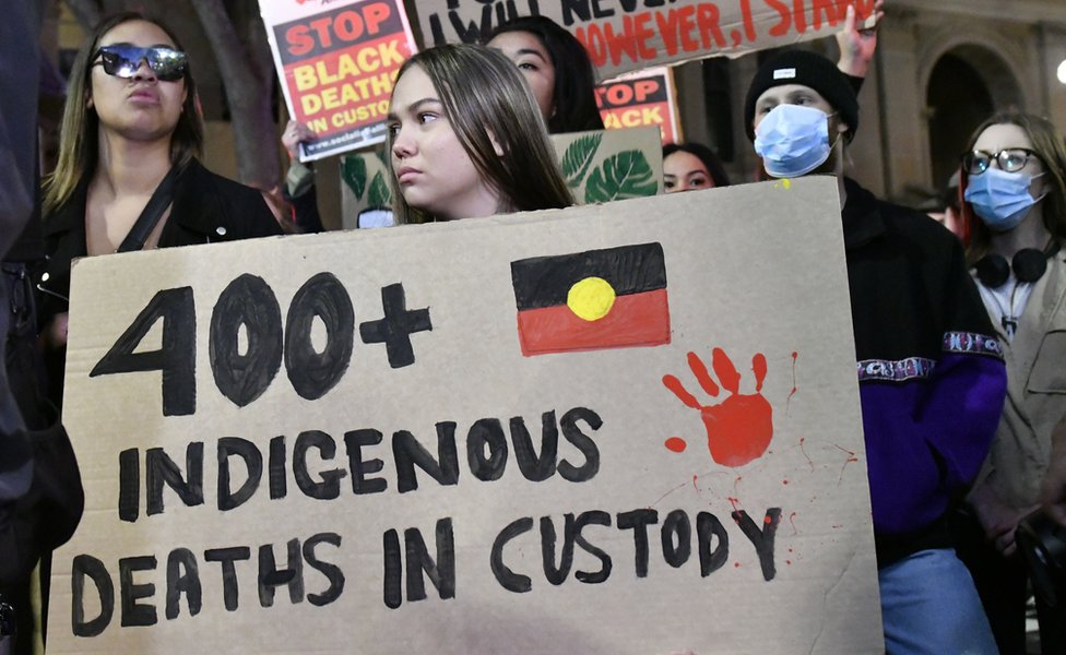 A protester at Sydney's Black Lives Matter march holds up a sign which reads '400 indigenous deaths in custody'