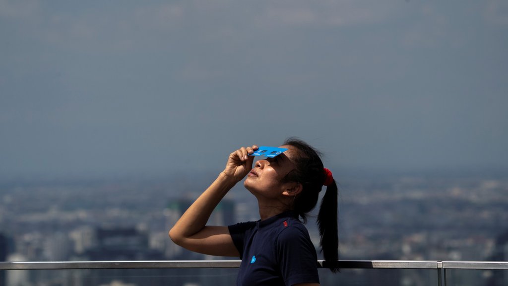Žena gleda pomračenje u Bangkoku