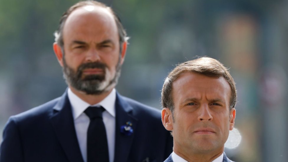 French President Emmanuel Macron (front) and French Prime Minister Edouard Philippe (L) attend a ceremony to mark the end of World War II at the Arc de Triomphe in Paris on May 8, 2020.