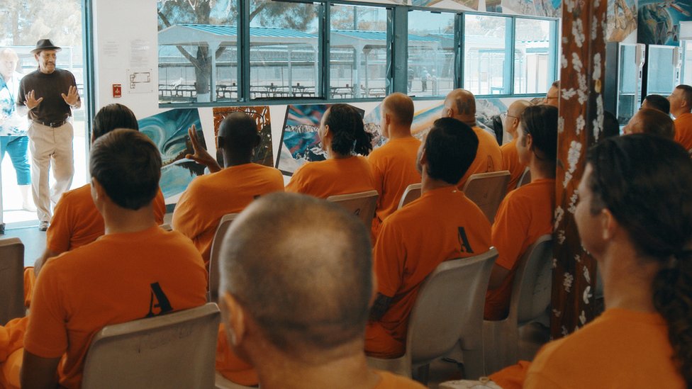 U filmu, Deni se vraća iza rešetaka kao motivacioni govornik za zatvorenike