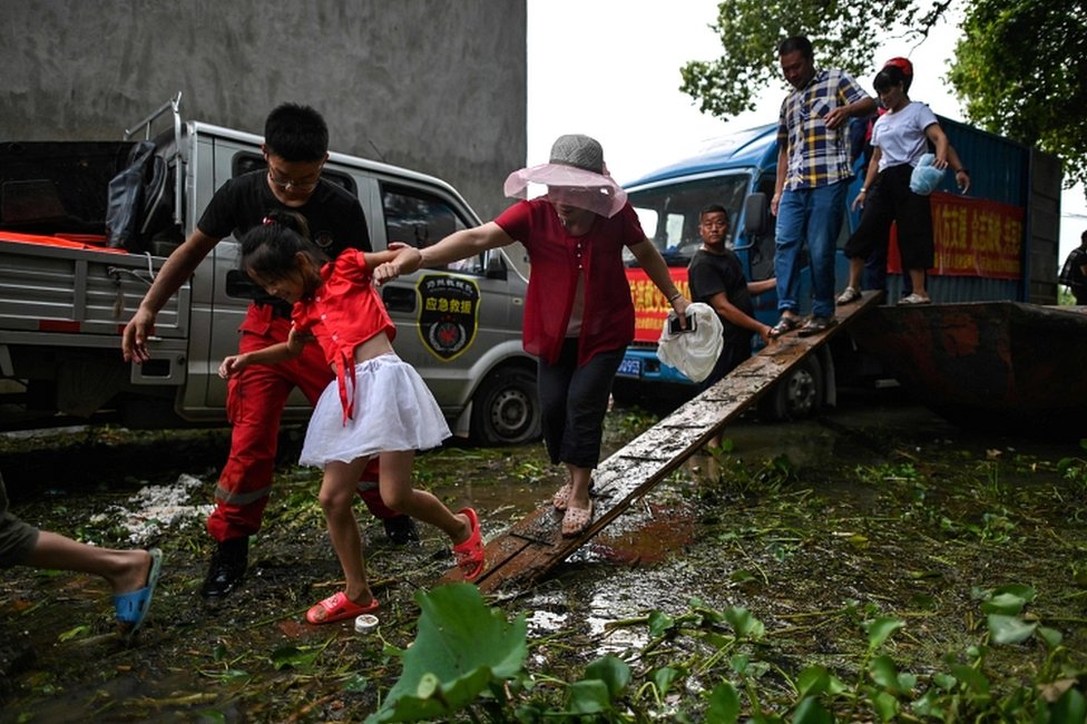 Stanovnici poplavljenog sela Longkou izlaze iz spasilačkog čamca u okrugu Pojang, 16. jul 2020.