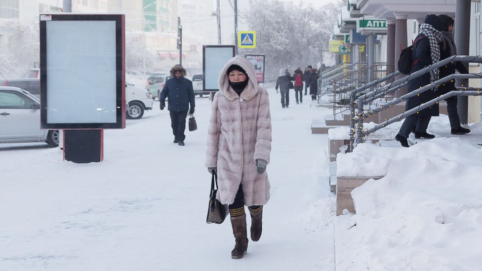 Woman walk trough the snow in Yakutsk