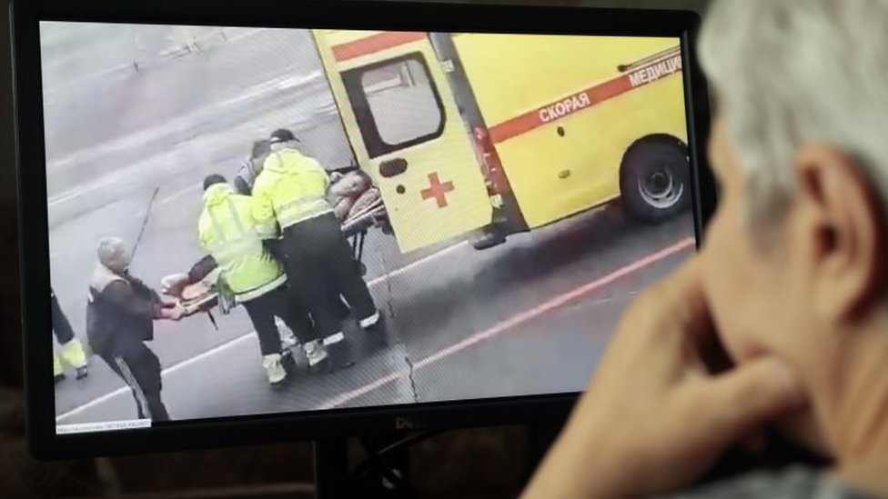 Aleksej Navaljni: Ruski opozicioni lider u previše teškom stanju da bi bio prebačen u Nemačku na lečenje, kažu ruski lekari 3 A man in Moscow watches social media footage of Mr Navalny being stretchered to an ambulance