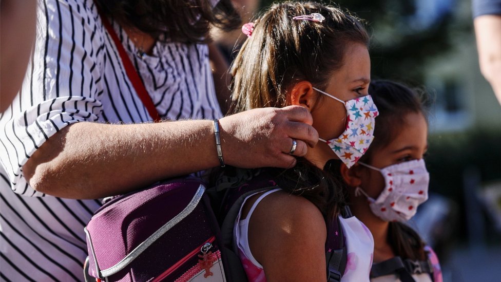 Korona virus: Stručnjaci tvrde da se situacija u Srbiji poboljšava, u Berlinu protest protiv novih mera 1 Children have their masks adjusted on the way to school in Germany