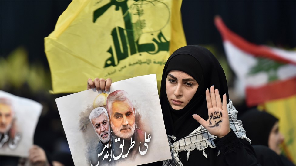 Hezbollah supporter holds up a photo of Abu Mahdi al-Muhandis and Qasem Soleimani at a rally in Beirut, Lebanon (5 January 2020)