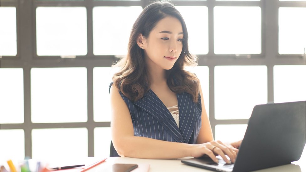 Young Chinese woman typing on her laptop