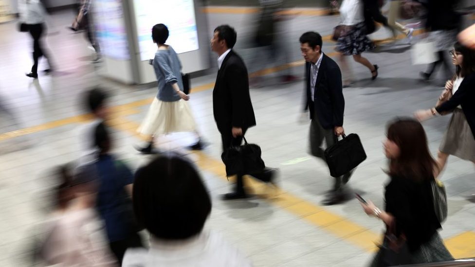 People walking at a Japanese train station