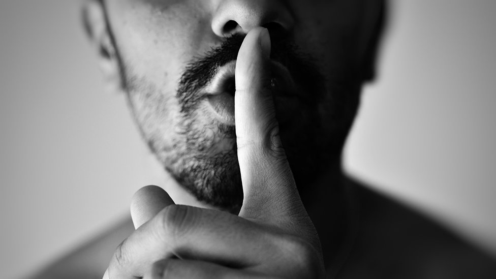 Man with finger against his lips