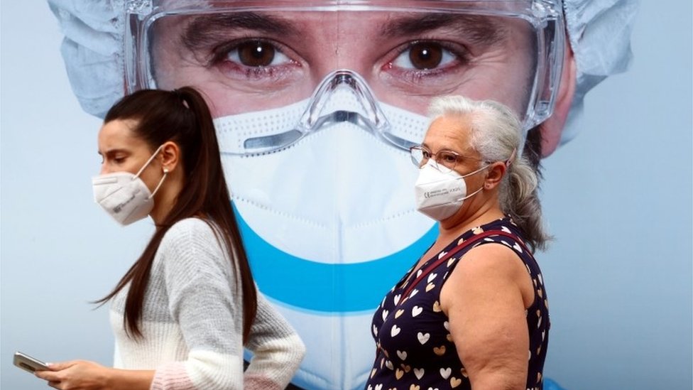 Korona virus: U Srbiji jedna osoba preminula, Džonson govorio o „mračnim trenucima i svetloj budućnosti“ 1 People, wearing protective face masks, walk past a dental clinic advertisement at Vallecas neighbourhood in Madrid, Spain, September 18, 2020.