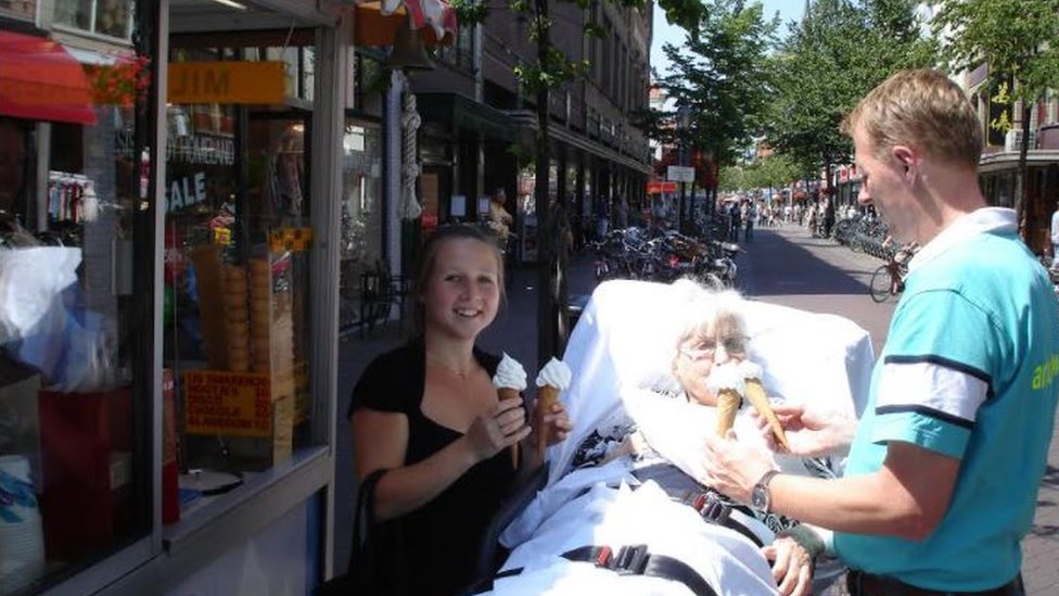 Kees Veldboer feeding ice-cream to a sick woman