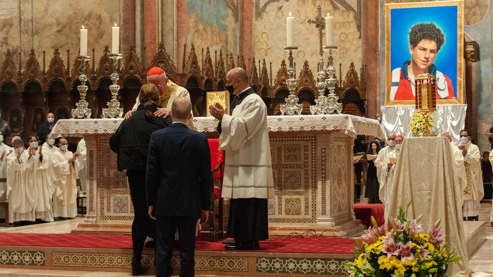 Cardinal Agostino Vallini greets the mother and father of Carlo Acutis as he celebrates Mass for the beatification process