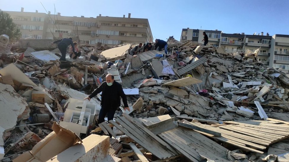 Zemljotres u Turskoj i Grčkoj: Jačina sedam stepeni, porušene zgrade u Izmiru, osetio se u Atini i Istanbulu 1 A man walks among debris of collapsed buildings after a magnitude 6.6 quake shook Turkey's Aegean Sea coast