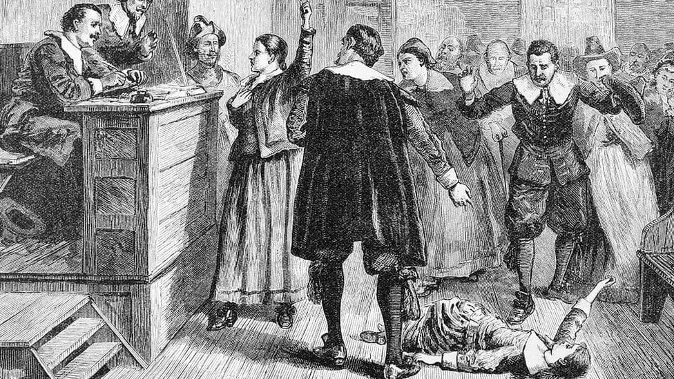 A girl is depicted on the floor during a witch trial in Salem