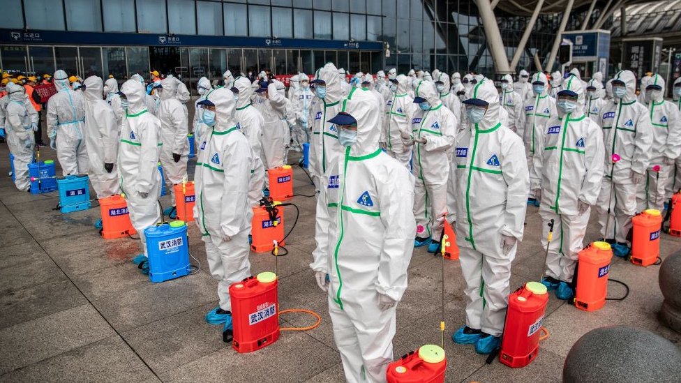 Korona virus: Kako je Vuhan postao najposećeniji grad u Kini 5 A squad of workers prepare to carry a disinfection operation at a Wuhan train station in March