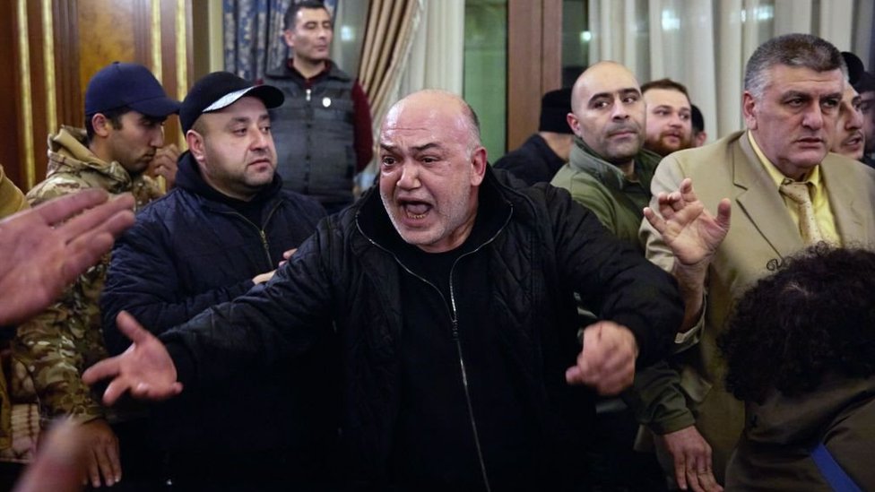 A man shouts angrily among a crowd of protesters who have stormed Armenian Prime Minister, Nikol Pashinyan's office