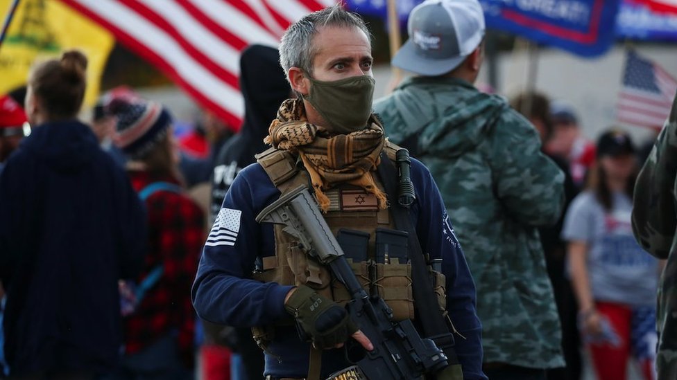 Američki izbori 2020: Šta Trampov poraz znači za „čvrste momke“ sa desnice 6 A supporter of US President Donald Trump carries a semi-automatic riflevduring a "Stop the Steal" protest in Phoenix, Arizona, on 8 Nov 2020