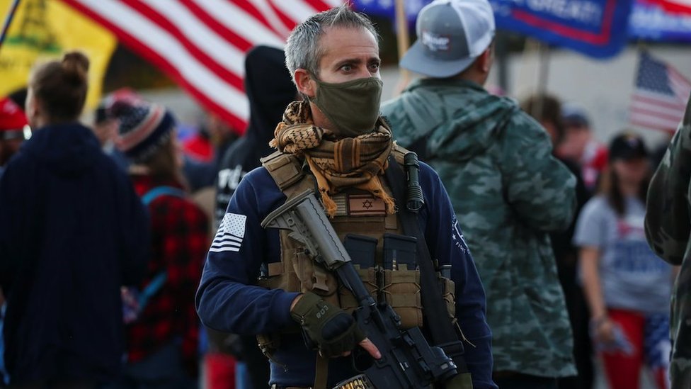 A supporter of US President Donald Trump carries a semi-automatic riflevduring a "Stop the Steal" protest in Phoenix, Arizona, on 8 Nov 2020