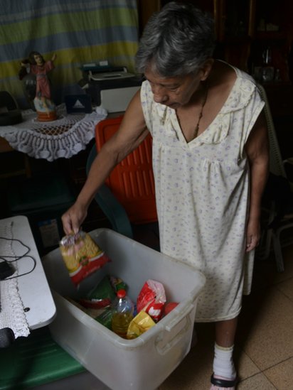 Norma Mújica shows the staples that come with the government good box