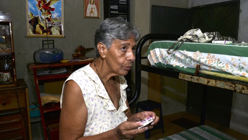 Norma Mújica holds a box of pills