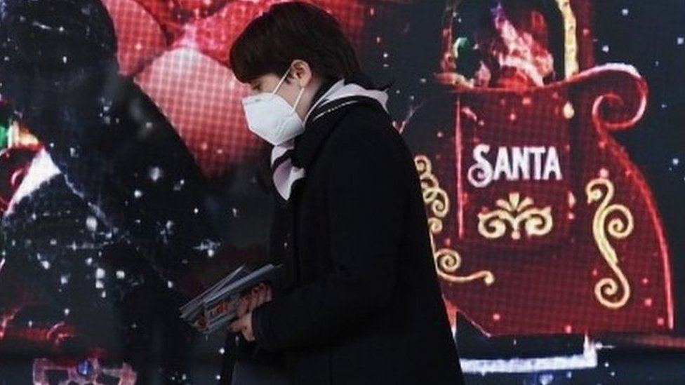 Korona virus: Stiglo 5.000 doza ruske vakcine u Srbiju, prvi slučaj novog soja u Americi 1 A woman wearing a face mask walks by the window of a shop in Milan