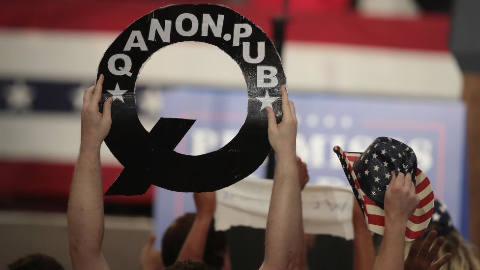 QAnon supporters bring banners and flags to rallies in support of President Trump
