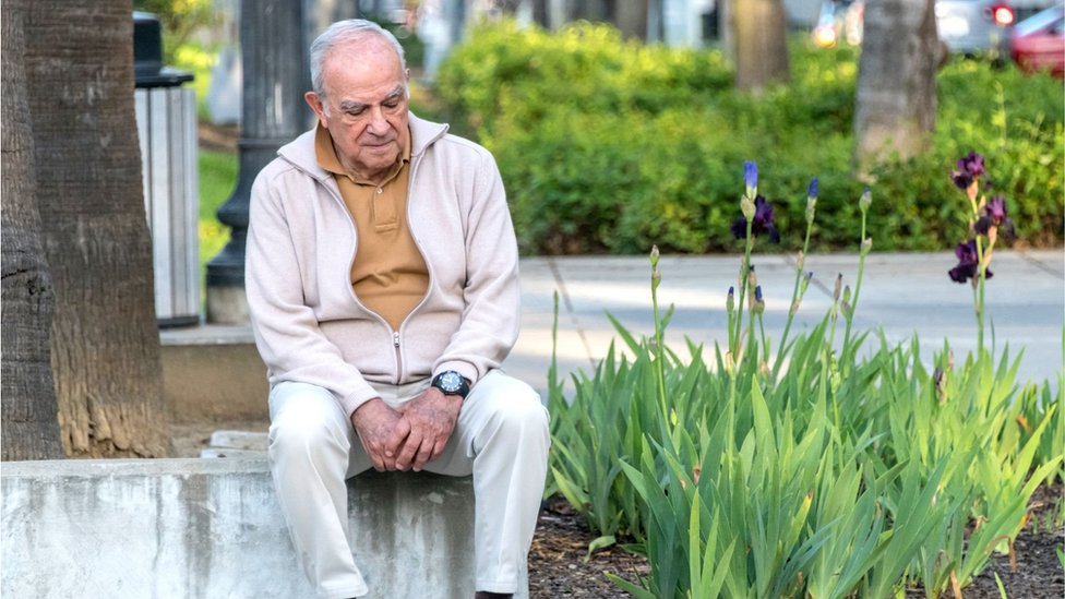 Elderly man sitting alone in a park