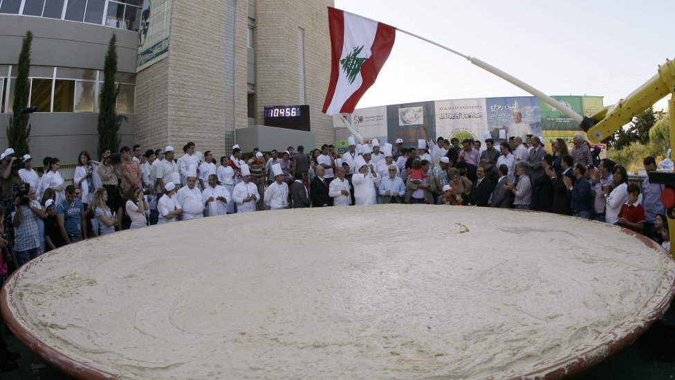Lebanese chefs celebrate around the largest plate of hummus after setting a new Guinness world record in Beirut on May 8, 2010