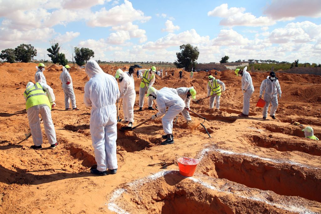 Libija i ratni zločini: Šestorica braće i njihovi lavovi terorisali meštane malog grada 8 Men in white protection suits digging up bodies of the dead