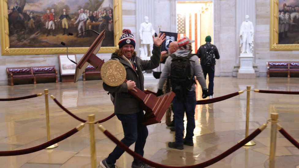 One protester carries a plinth from a room in the US Capitol
